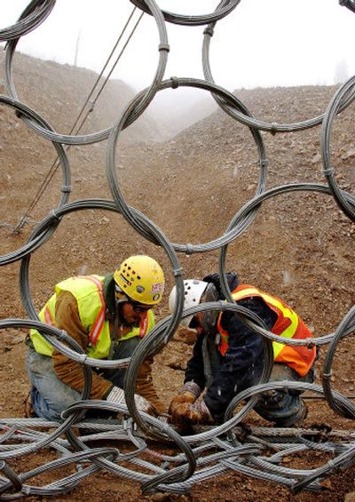 
Brian Manley, left, and Andrew Worley install a debris barrier on the Beartooth Highway near Red Lodge, Mont. 
 (Associated Press / The Spokesman-Review)