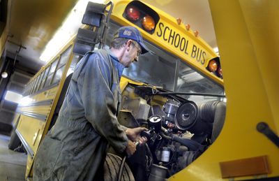 Mead School District mechanic John Huffman prepares to change the oil of  one of the district’s buses Wednesday.  (Christopher Anderson / The Spokesman-Review)