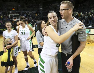 Oregon's Sabrina Ionescu, center left, gets a hug from acting head coach Mark Campbell, right, after their win over Air Force on Thursday. (Chris Pietsch / Associated Press)