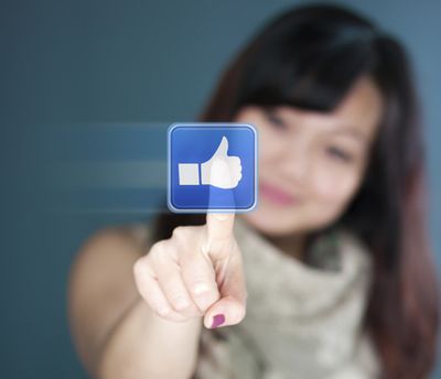 Cute young woman is touching the like button (Alexander Kirch)