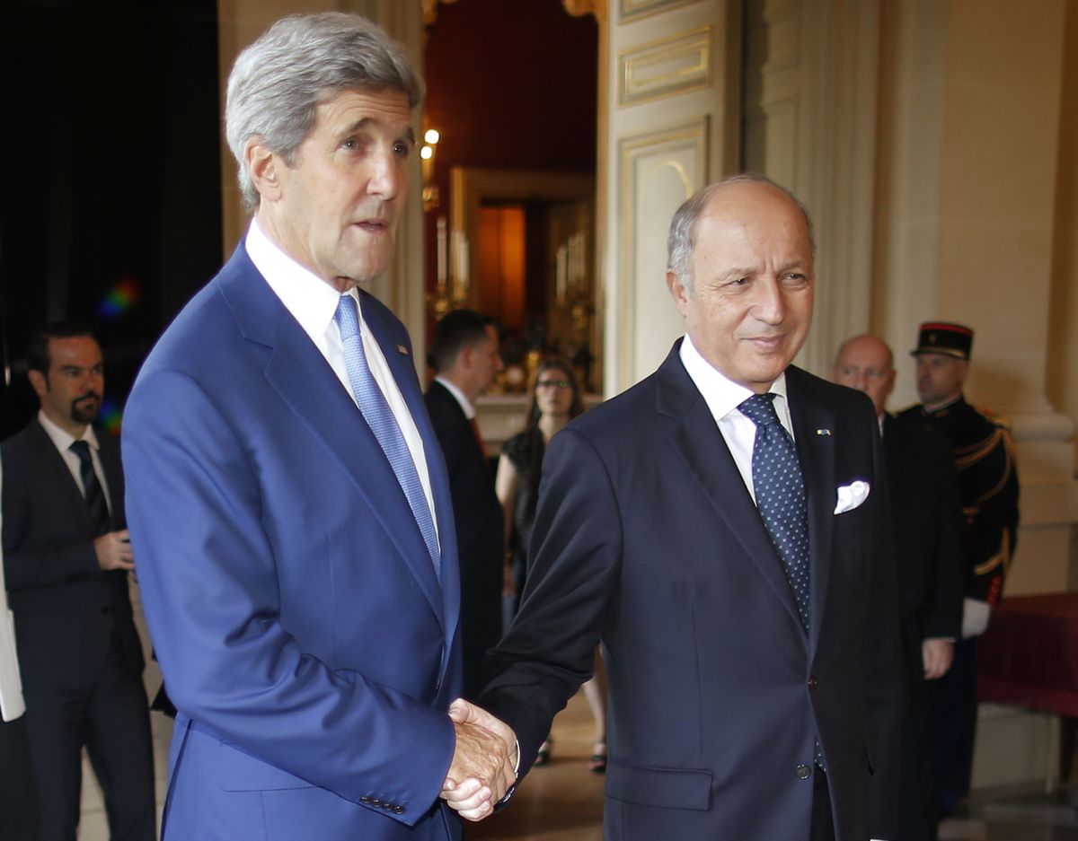 U.S. Secretary of State John Kerry, left, is greeted by France
