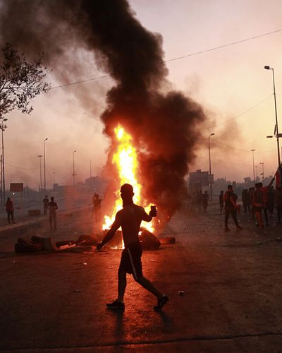 Anti-government protesters set fires and close a street during a demonstration in Baghdad, Iraq, Saturday, Oct. 5, 2019. The spontaneous protests which started Tuesday in Baghdad and southern cities were sparked by endemic corruption and lack of jobs. Security responded with a harsh crackdown, killing dozens. (Hadi Mizban / Associated Press)