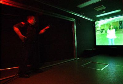 
In the Firearms Training Simulator, Sgt. Ray Bourgeois of the Liberty Lake Police Department speaks to a distraught woman about a man with a knife. 
 (Liz Kishimoto / The Spokesman-Review)