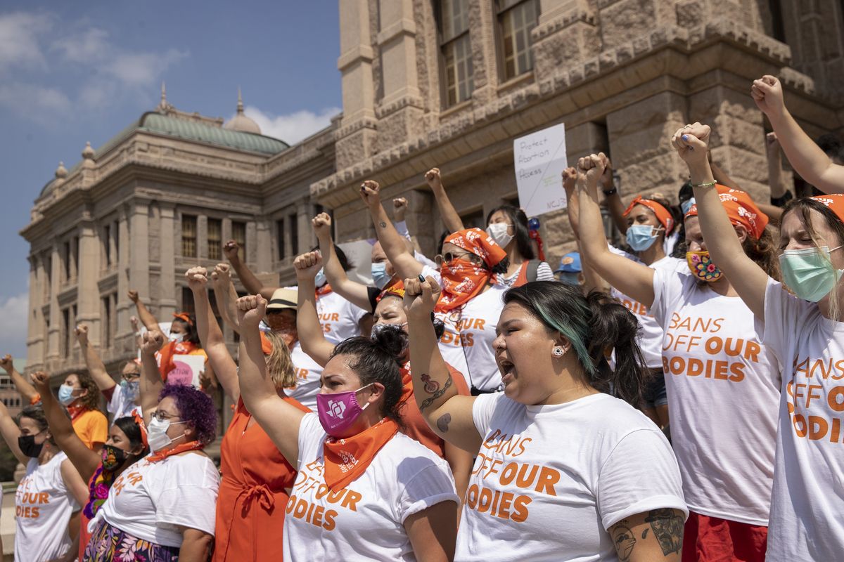 In this Wednesday, Sept. 1, 2021, file photo, women protest against Texas' restrictive abortion law at the Capitol in Austin, Texas. A federal judge on Friday, Oct. 1, 2021, will consider whether Texas can leave in place the most restrictive abortion law in the U.S., which since September has banned most abortions and sent women racing to get care beyond the borders of the nation's second-largest state.  (Jay Janner/Associated Press)