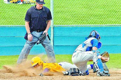 
Lewiston's Adam Carson, now hitting .583, slides home safely as the ball bounces off the glove of CdA catcher Vinny Lupinacci. 
 (Jesse Tinsley / The Spokesman-Review)