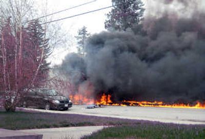 
Flames engulf the wreckage of a helicopter crash in a residential area of Cranbrook, B.C., on Tuesday. Three people aboard the helicopter were killed, along with a passerby.Associated Press
 (Associated Press / The Spokesman-Review)