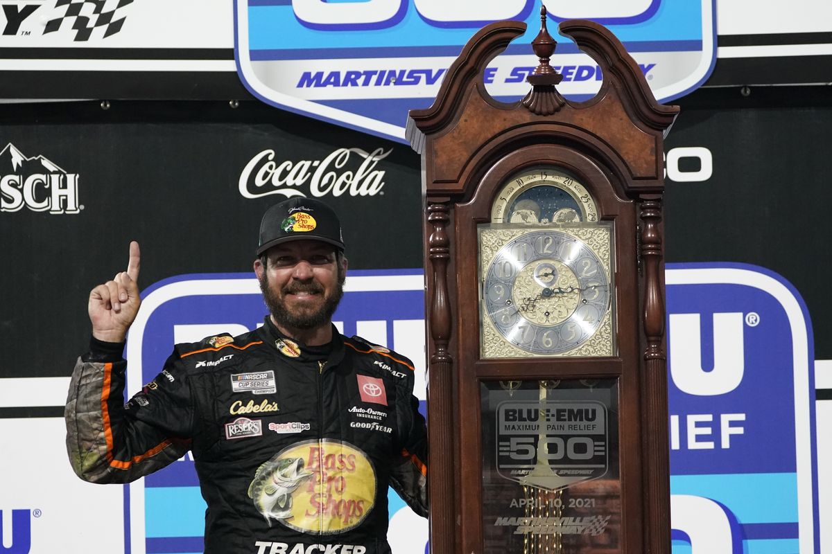 Martin Truex Jr. (19) celebrates with the winners' trophy after winning the NASCAR Cup Series auto race at Martinsville Speedway in Martinsville, Va., Sunday, April 11, 2021.  (Associated Press)