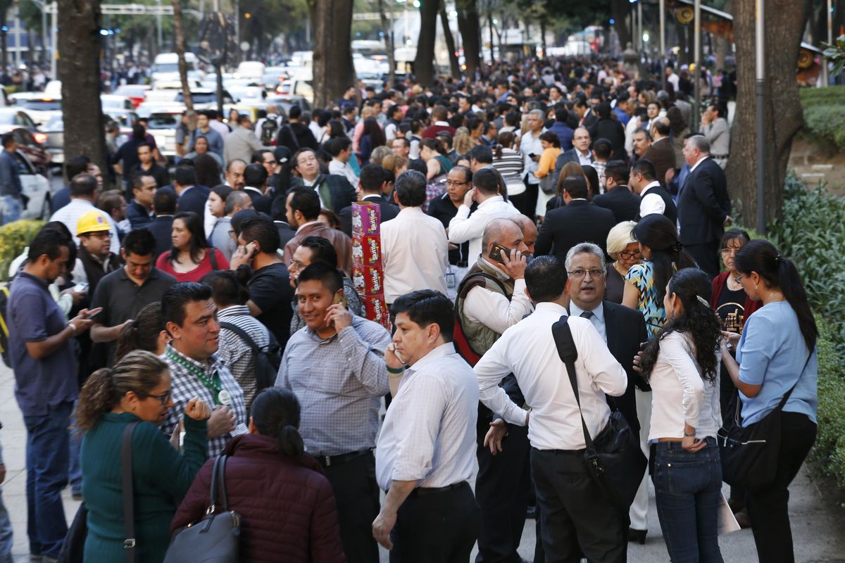People stand along Reforma Avenue after a 7.2-magnitude earthquake shook Mexico City, Friday, Feb. 16, 2018. A powerful earthquake has shaken south and central Mexico, causing people to flee buildings and office towers in the country’s capital, and setting off quake alert systems. (Marco Ugarte / Associated Press)