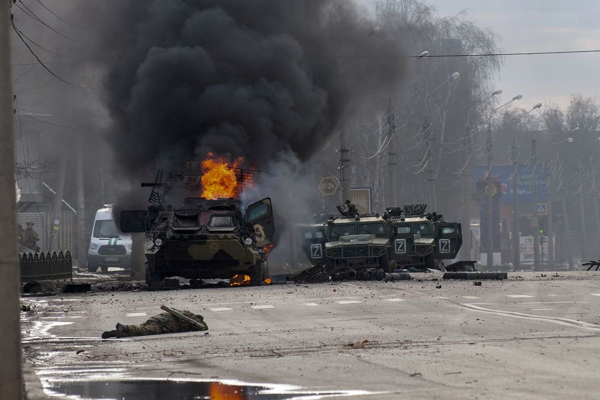 FILE - A Russian armored personnel carrier burns amid damaged and abandoned light utility vehicles after fighting in Kharkiv, the country