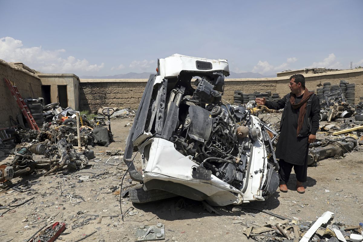 An Afghan man looks at a damaged vehicles in Baba Mir