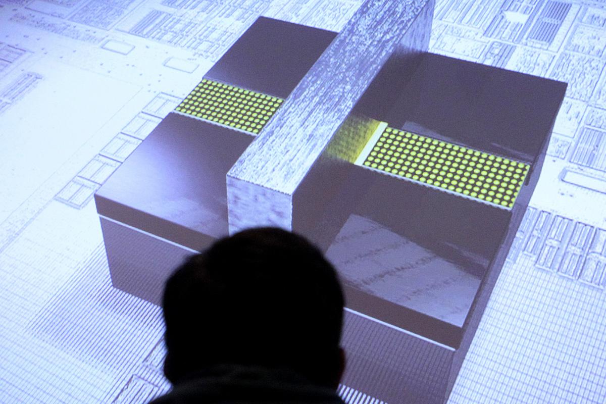 A reporter watches a video image of an Intel 3-D transistor at an Intel announcement in San Francisco on Wednesday. Intel Corp. said it has redesigned the electronic switches on its chips so that computers can keep getting cheaper and more powerful. (Associated Press)