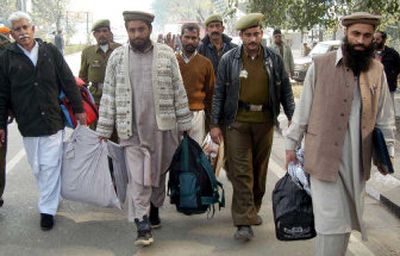 
Pakistani prisoners are escorted by Indian policemen before they cross over the India and Pakistan joint border check post in Wagah, India, on Monday. Eight Pakistani prisoners were freed from jails in India as part of peace efforts Monday.
 (Associated Press / The Spokesman-Review)