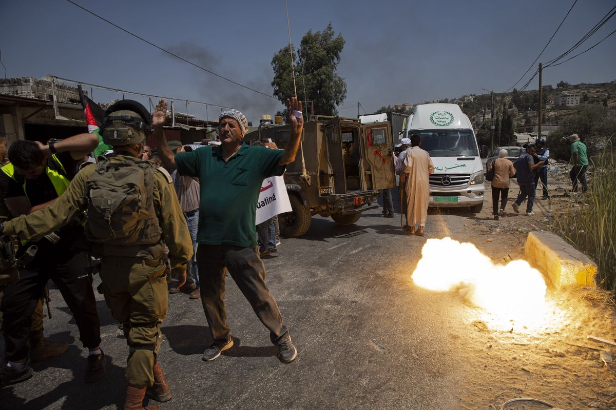 A sound grenade is fired by Israeli forces during a protest against the creation of a new road for Israeli settlers, near the Palestinian village of Beita, north of the West Bank city of Nablus, Wednesday, Aug. 25, 2021.  (Majdi Mohammed)