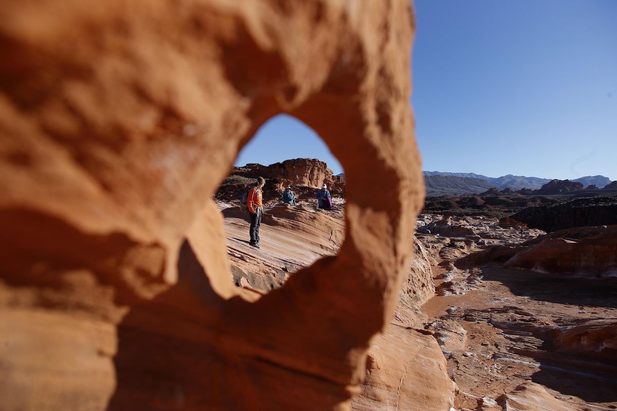 Visitors hike at Gold Butte National Monument in Gold Butte, Nev., prior to a July visit by U.S. Interior Secretary Ryan Zinke. The monument is among about 14 that may be altered by the Trump administration. (Christian K. Lee / Associated Press)