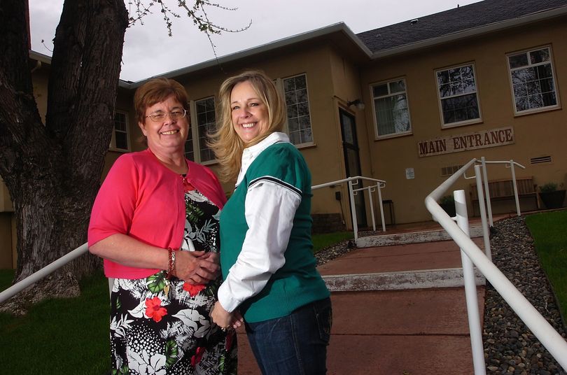 ORG XMIT: ORPEN101 Kay Rene Qualls, left, of Heppner, Ore., and DeeAnn Shafer, of Richland, Wash., pose for a photo in front of the Pioneer Memorial Hospital in Heppner, Ore., May 6, 2009. They found out recently that they were switched shortly after being born 56 years ago. (AP Photo/E.J. Harris, East Oregonian) (E.j. Harris / The Spokesman-Review)