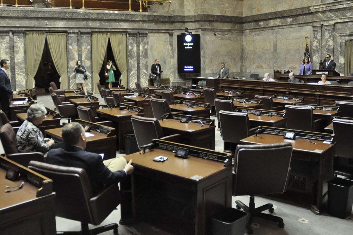 In a mostly empty Senate chamber, Sen. Joe Fain, standing far left, moves for the first special session of the Legislature to adjourn while Sens. Sharon Nelson and David Frockt look on in Olympia. (Jim Camden / The Spokesman-Review)