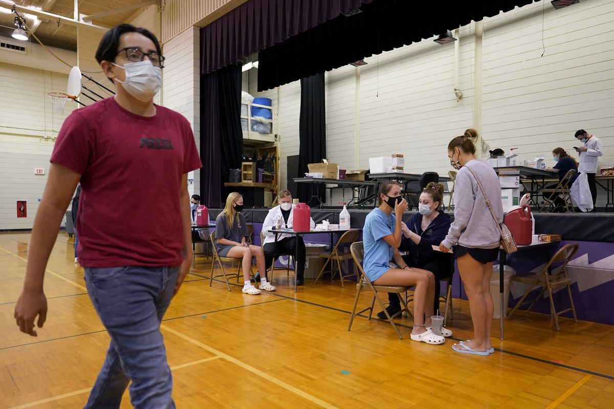 FILE - In this June 11, 2021, file photo, healthcare workers administrate a dose of the Pfizer COVID-19 vaccine to students during a vaccination clinic hosted by Jewel Osco in Wheeling, Ill. The latest alarming coronavirus variant, the delta variant, is exploiting low global vaccination rates and a rush to ease pandemic restrictions, adding new urgency to the drive to get more shots in arms and slow its supercharged spread.  (Nam Y. Huh)
