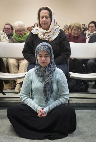 At the Spokane Interfaith Council Meet the Neighbors event  at the Spokane Islamic Center, Natalie Palmer and her daughter Libby, 16, respectfully listen to a call to prayer Tuesday. The Palmers are members of the Unitarian Universalist Church and said they came to the open house to support their Islamic neighbors. “They are my friends, neighbors, co-workers and students,”  Natalie said. (Colin Mulvany / The Spokesman-Review)