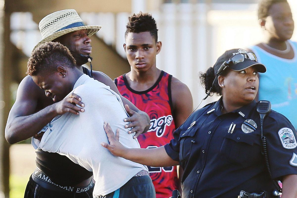People embrace after a fatal shooting at Club Blu in Fort Myers, Fla., Monday, July 25, 2016. (Kinfay Moroti / The News-Press via AP)