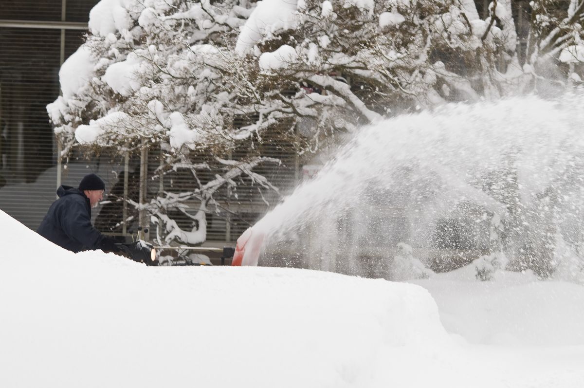 Ferris High School custodian Jim Gomez clears a walkway at the school Monday.  (Colin Mulvany / The Spokesman-Review)