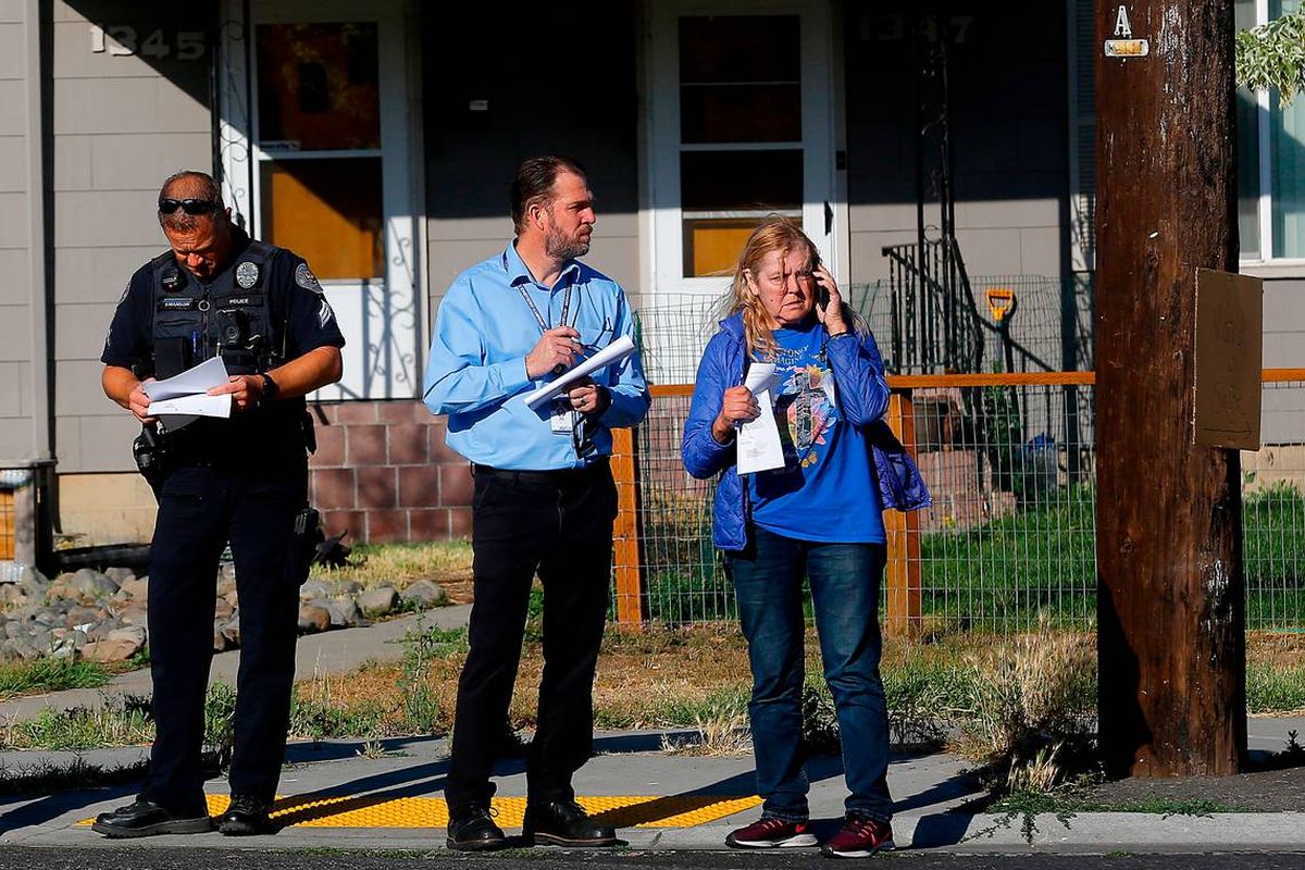 Joe Schiessl, Richland deputy city manager, stands with Linda Alexander, the owner of the burned out house, as demolition crews prepare to demolish the gutted structure.  (Bob Brawdy/Tri-City Herald)