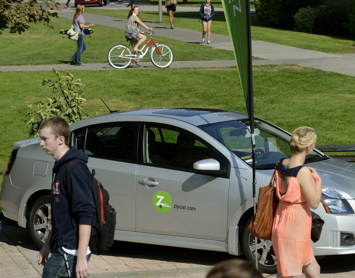 Gonzaga University students, on foot, bikes and skateboards, make their way past a Zipcar Thursday. (Dan Pelle)