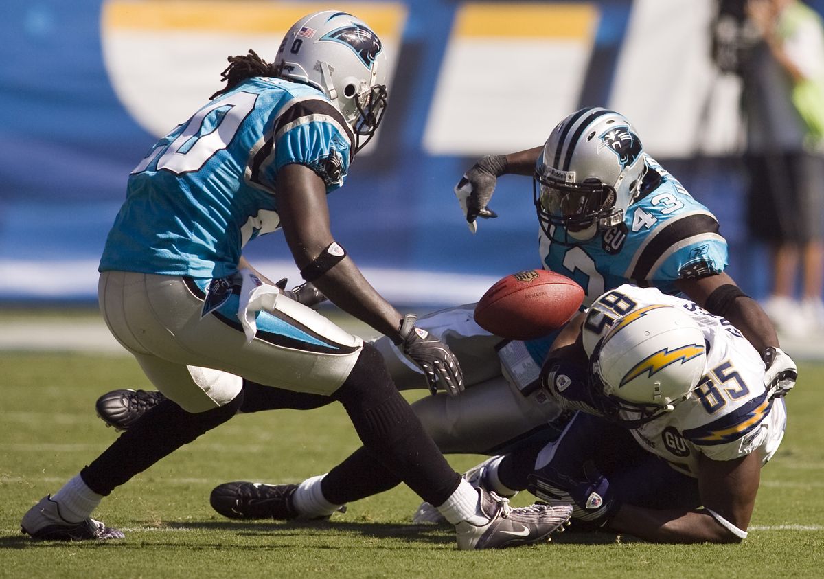 Chargers tight end Antonio Gates (85) fumbles as he is hit by Carolina’s Chris Gamble, left, and Chris Harris.  (Associated Press / The Spokesman-Review)