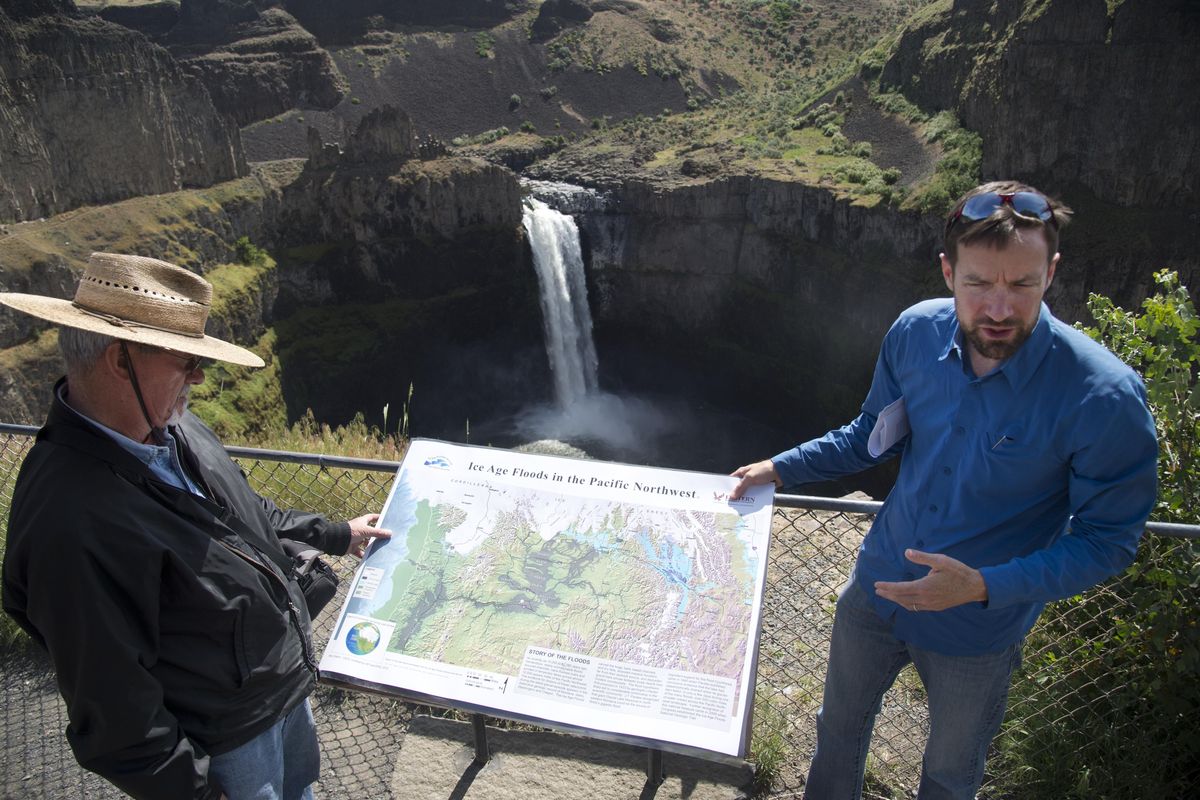 Standing on the overlook above Palouse Falls, Chad Pritchard, right, an assistant professor of geology at Eastern Washington University, talks about the geology and history of the falls and the surrounding area of Eastern Washington scablands, Friday, May 20, 2016. Brad Brown, a soil scientist, stands at left. The rocky outcroppings were left by ancient lava flows and the sculpting of the landscape were likely caused by an ice age flood. (Jesse Tinsley / The Spokesman-Review)