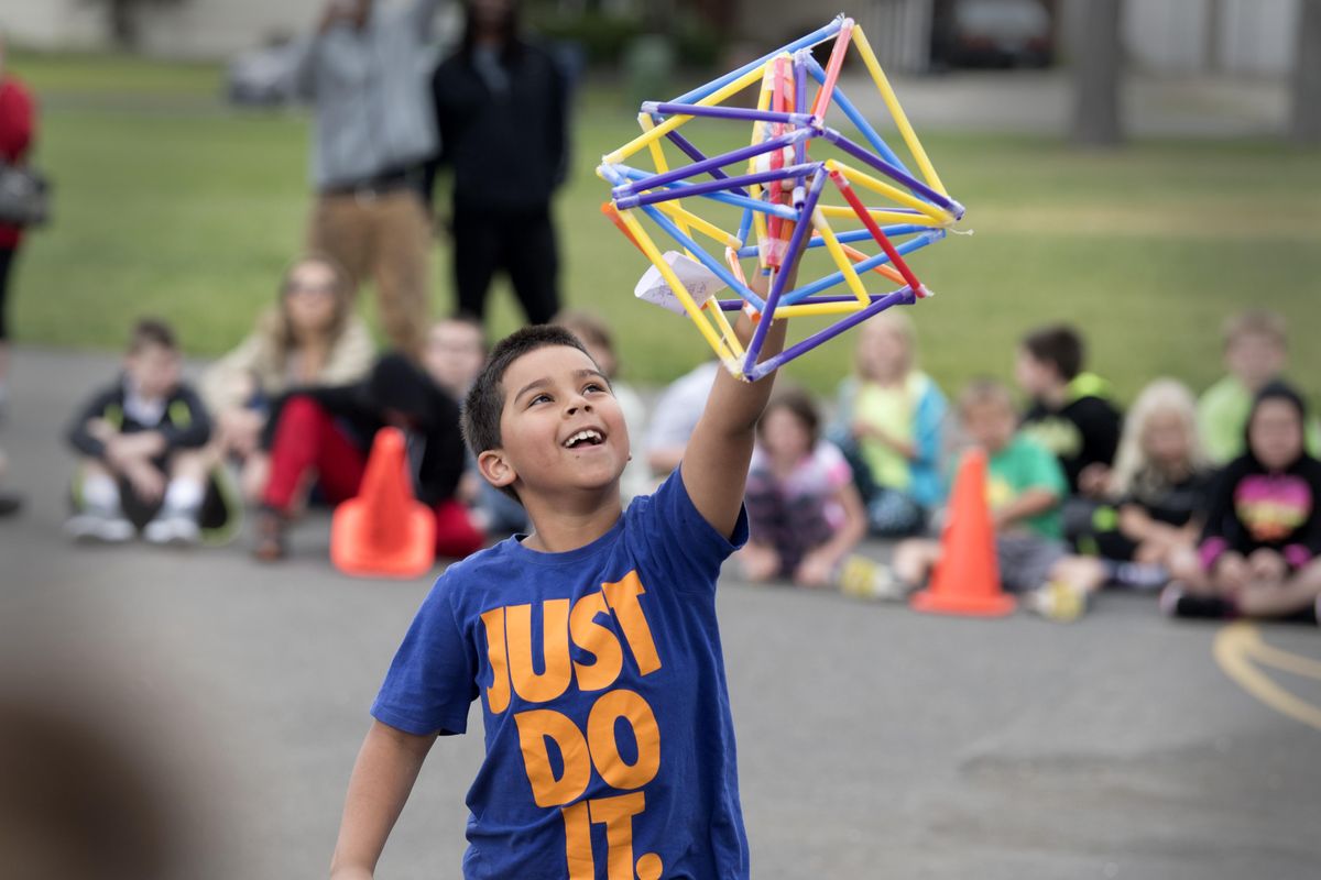 Second-grader Jordan Adams, celebrates the survival of the raw egg suspended in a cage of plastic straws Thursday, June 1, 2017, after it was dropped by a firefighter from 25 feet at Westview Elementary in North Spokane. Most of the student body tried their hand at designing a package that would keep the egg whole when dropped. (Jesse Tinsley / The Spokesman-Review)