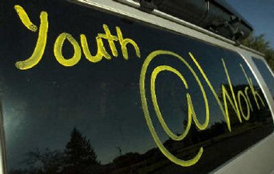 A sign on the window of a vehicle lets the community know what is going on as a team of volunteers works on a house.
(The Spokesman-Review)