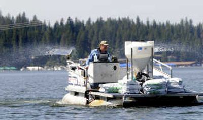 Driving a pontoon boat, AquaTechnex worker Terry McNabb spreads a mix of granular herbicide and water on Lake Coeur d'Alene on Tuesday. McNabb used GPS technology to guide the boat to spots where previous surveys found Eurasian milfoil, an invasive weed.
 (Jesse Tinsley / The Spokesman-Review)