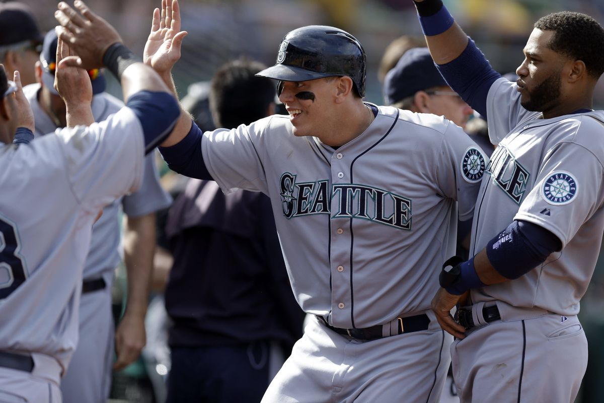 Logan Morrison, center, is congratulated after scoring in the 11th inning, providing the go-ahead run that led to the first MLB win for Spokane Valley’s Tyler Olson. (Associated Press)