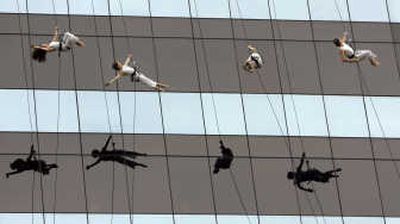 
Associated Press photos Members of Project Bandaloop of Oakland, Calif., rappel down Chrysler headquarters Monday in Auburn Hills, Mich. Chrysler, which became a private company Monday, has been struggling to make a profit amid falling sales and rising pension and health costs.
 (Associated Press photos / The Spokesman-Review)