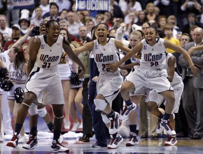 Tina Charles, left, Maya Moore, center, and Renee Montgomery celebrate UConn’s perfect season. (Associated Press / The Spokesman-Review)