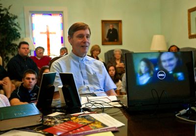 The Rev. Dave Amidon of St. Philip Lutheran Church in Raleigh, N.C., uses a Skype video conference to talk with Chad and Natalie Rimmer, reflected on the monitor, in Denmark, on Feb.15. McClatchy (McClatchy / The Spokesman-Review)
