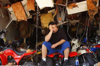
Gerard Campanella, the owner of the Bicycle Center on U.S. 41 in Port Charlotte, Fla., sits among the debris of his business, which was in the path of Hurricane Charley. .
 (Associated Press / The Spokesman-Review)