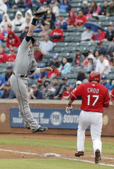 Seattle Mariners first baseman Justin Smoak (17) is forced to leap to make the catch, allowing Texas Rangers' Shin-Soo Choo (17) to reach first safely, during the eighth inning  Thursday in Arlington, Texas. Texas won 8-6. (Associated Press)