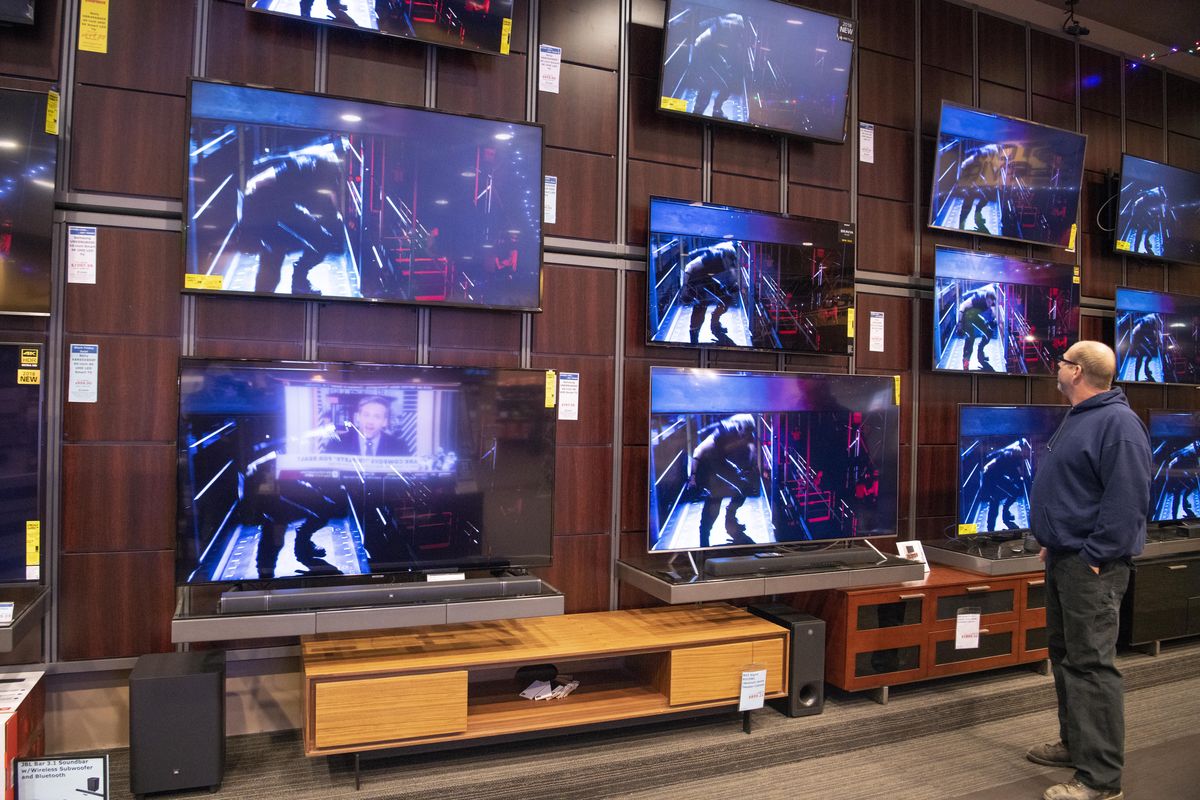 Scott Haisley peruses a wall of giant televisions, many with the latest smart features such as ultra high definition, at Huppin’s in North Spokane, Friday, Nov. 23, 2018. (Jesse Tinsley / The Spokesman-Review)