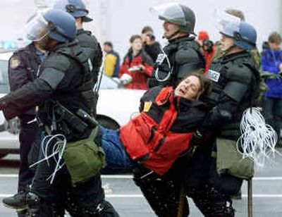 
Seattle police officers carry away a demonstrator detained during World Trade Organization protests, Dec. 1, 1999. A federal appeals court ruled Thursday that the city had the right to block parts of downtown Seattle in 1999 when the WTO protests turned violent. But the three-judge panel of the 9th U.S. Circuit Court of Appeals reversed part of a lower court decision and sent it back for retrial, saying police trying to quell the unrest may have violated some demonstrators' constitutional rights.
 (File/Associated Press / The Spokesman-Review)