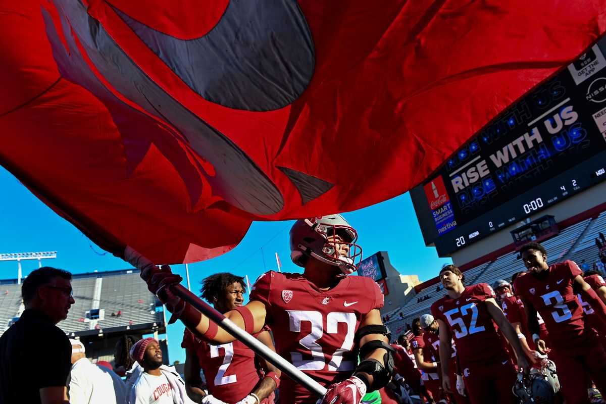 Washington State Cougars defensive back Tanner Moku (32) waves a WSU flag after WSU defeated the Arizona Wildcats during the second half of a college football game on Saturday, Nov. 19, 2022, at Arizona Stadium in Tucson, Ariz. WSU won the game 31-20.  (Tyler Tjomsland/The Spokesman-Review)