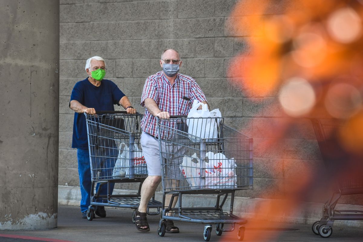 Bob Hayes, left, and Kirt Kring wear their face masks after shopping at WinCo Foods on Sept. 3 in Spokane Valley.  (DAN PELLE)