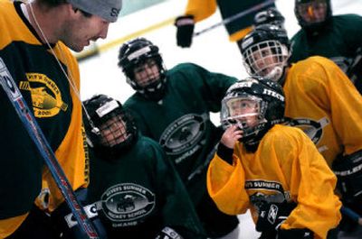 
National Hockey League player Cam Severson, left, leans in to listen to 7-year-old Nick Bryant during a training session at Sever's Summer Hockey School at Planet Ice. 
 (Holly Pickett / The Spokesman-Review)