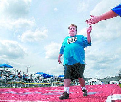 
Michael Parker hits the finish line of the 400-meter walk Saturday  at the Special Olympics spring games  at Spokane Community College. 
 (Dan Pelle / The Spokesman-Review)
