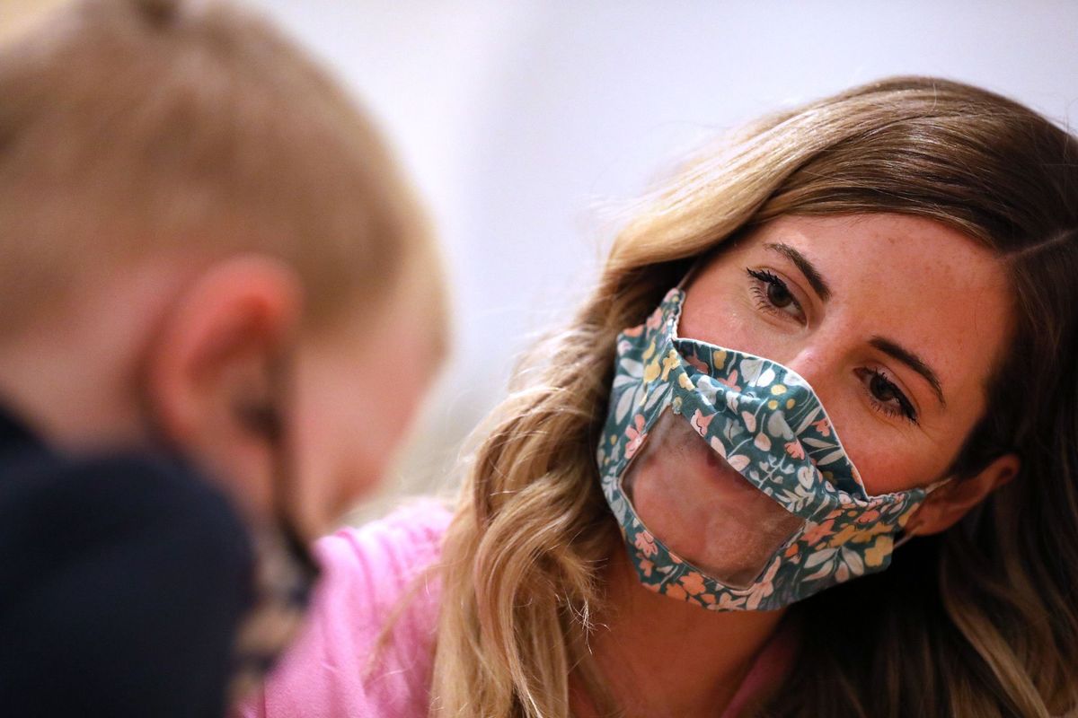 Pediatric speech language pathologist Jess Dieter wears a see-through mask while working with Jameson Kays, 4, at CST Academy in Chicago on April 13.  (Chris Sweda/Chicago Tribune)