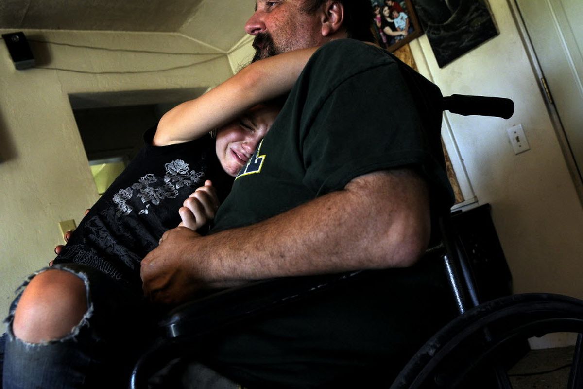 Eight-year-old Jacenta Bonagofski, cries while sitting on the lap of her father, Jerry  Bonagofski, at their home in Sandpoint on Friday, Aug. 7, 2009. Her mother, Carlene Bonagofski, died late Thursday night at Kootenai Medical Center. Jerry is on disability and Carlene provided the only steady income for the family of six.  (Kathy Plonka / The Spokesman-Review)