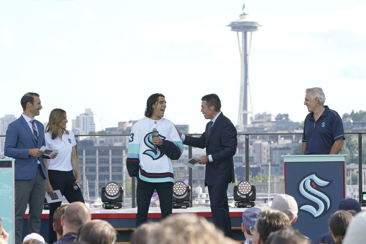 Brandon Tanev, center, a forward from the Pittsburgh Penguins, is introduced as a player for the Seattle Kraken, Wednesday, July 21, 2021, during the Kraken’s NHL hockey expansion draft event in Seattle. Looking on are ESPN hosts Dominic Moore, left, and Chris Fowler, second from right, and Kraken general manager Ron Francis, right, and Kraken scout Cammi Granato, second from left.  (Associated Press)
