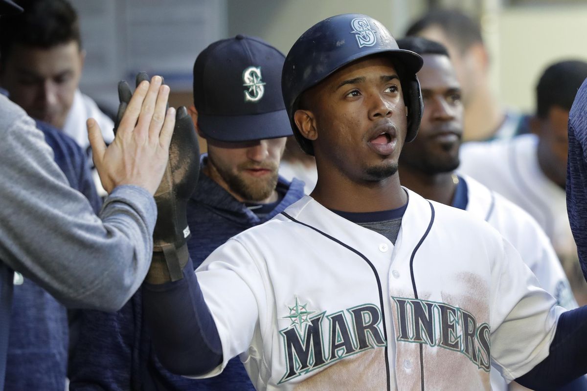 Seattle Mariners' Jean Segura is greeted in the dugout after he scored on a single by Nelson Cruz during the third inning of a baseball game against the Tampa Bay Rays, Saturday, June 2, 2018, in Seattle. (Ted S. Warren / AP)