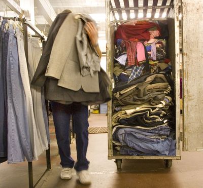 At the Salvation Army warehouse in downtown Seattle, a worker moves a load of donated clothing, February 25, 2007. This bunch has been sorted, priced, evaluated and deemed worthy of a local Salvation Army thrift store.  (Tom Reese/Seattle Times)