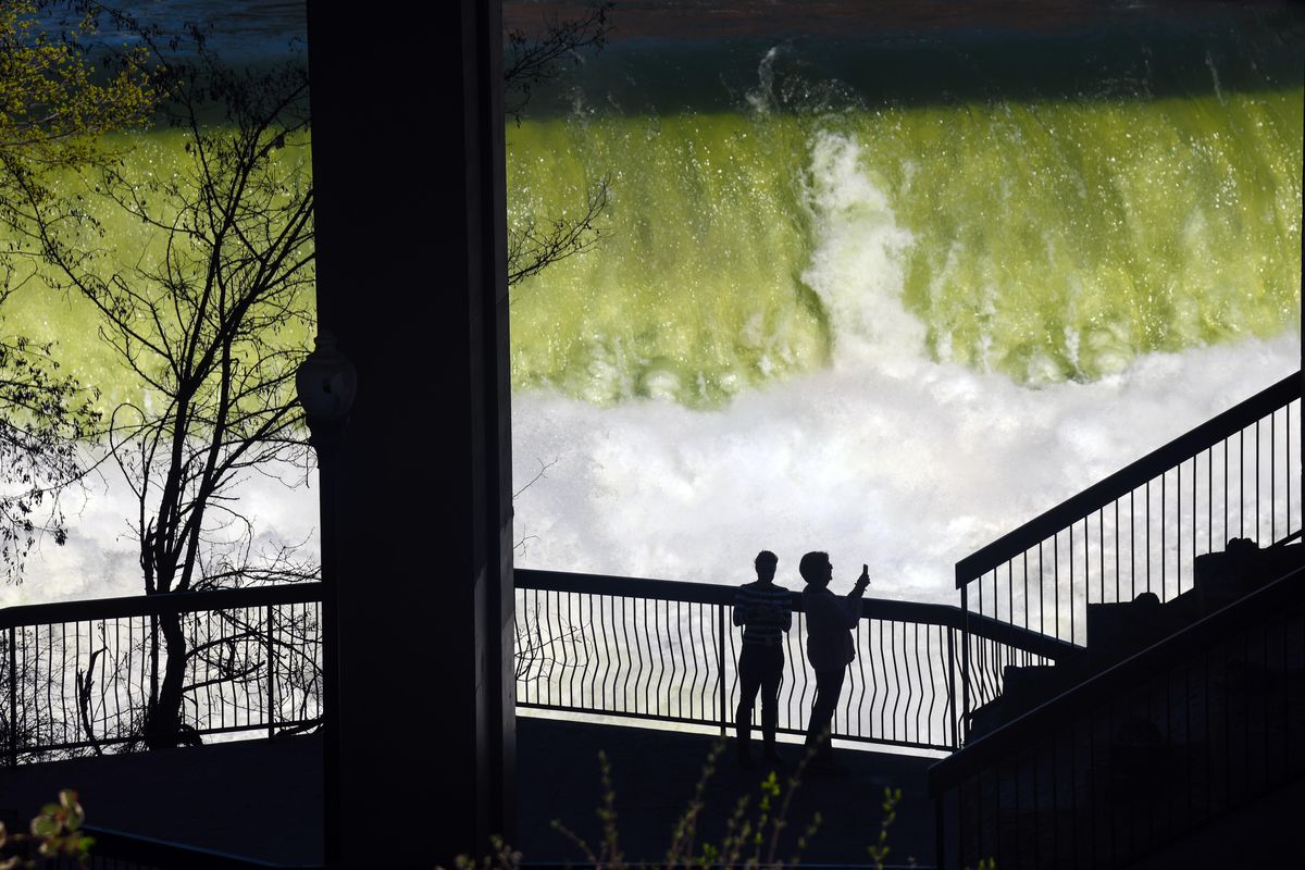 Sonja Haddad and Susie Long, of VisitSpokane, gather ideas for places to take convention goers during a Friday afternoon walk to the Lower Spokane Falls under the Monroe Street Bridge, April 20, 2018. (Dan Pelle / The Spokesman-Review)