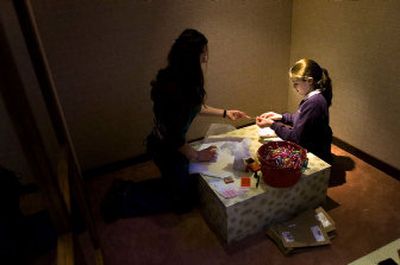 
Maggie Peterson, 11, finishes wrapping presents with the help of her 